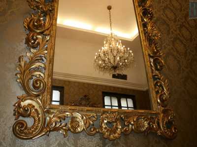 Uno dei lampadari riflesso in uno specchio anch'esso dorato